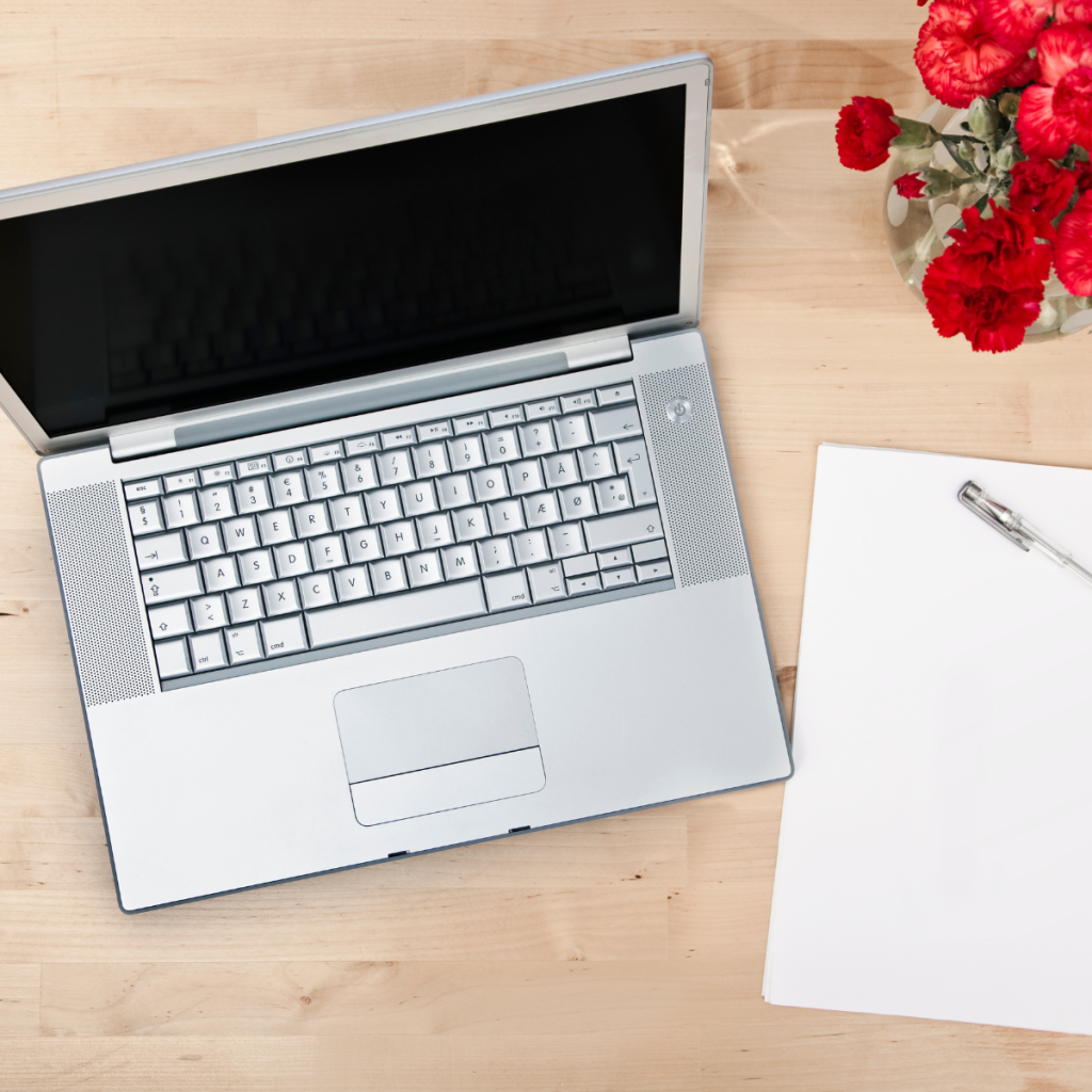 Large computer monitor, keyboard and laptop seen from above.