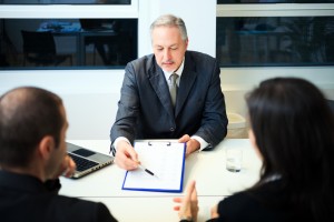 Male attorney pointing to signature area on business papers.