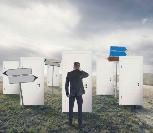 Man standing in front of multiple doors.