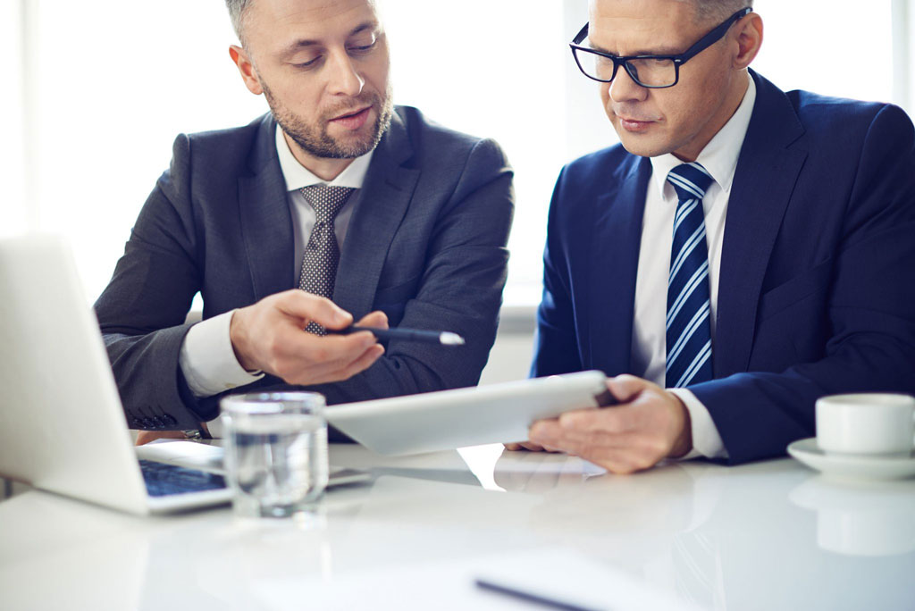 Two businessmen looking at at iPad.