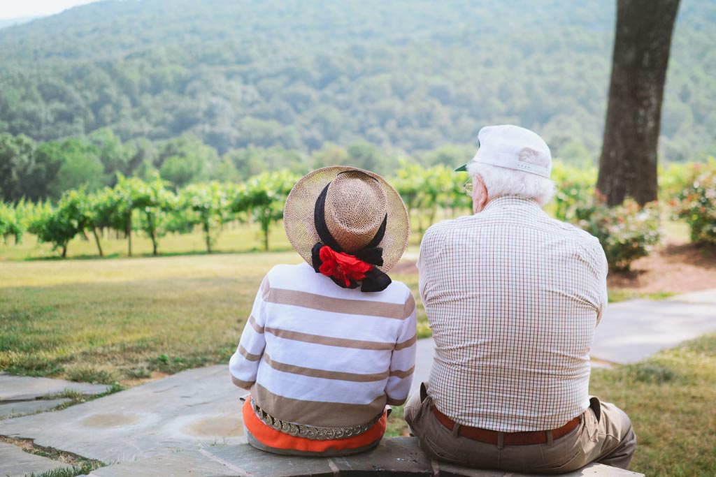 Older couple sitting outside, enjoying the view.