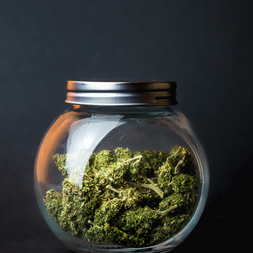 Marijuana in a small jar on desk.