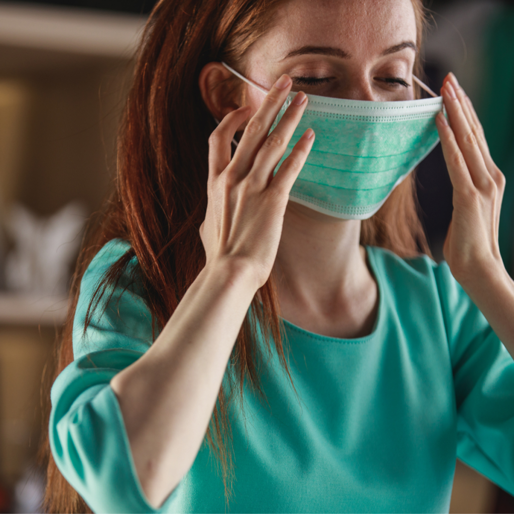 Woman adjusting her face mask.