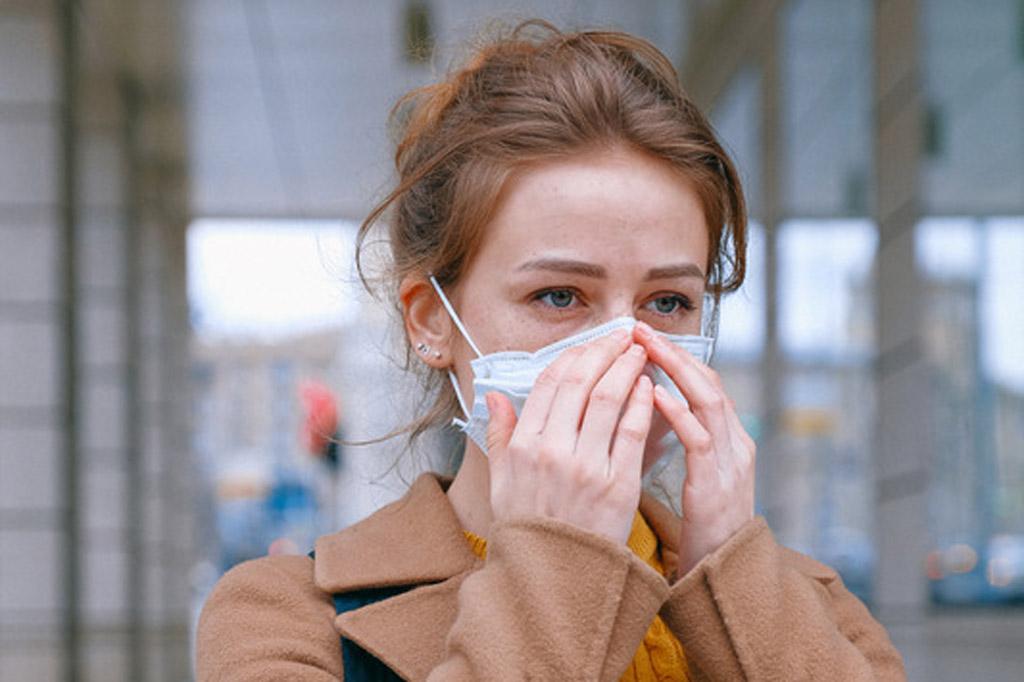 Woman adjusting her face mask.