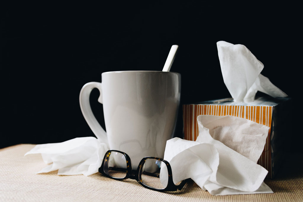 Mug, glasses, and a tissue box on a table.