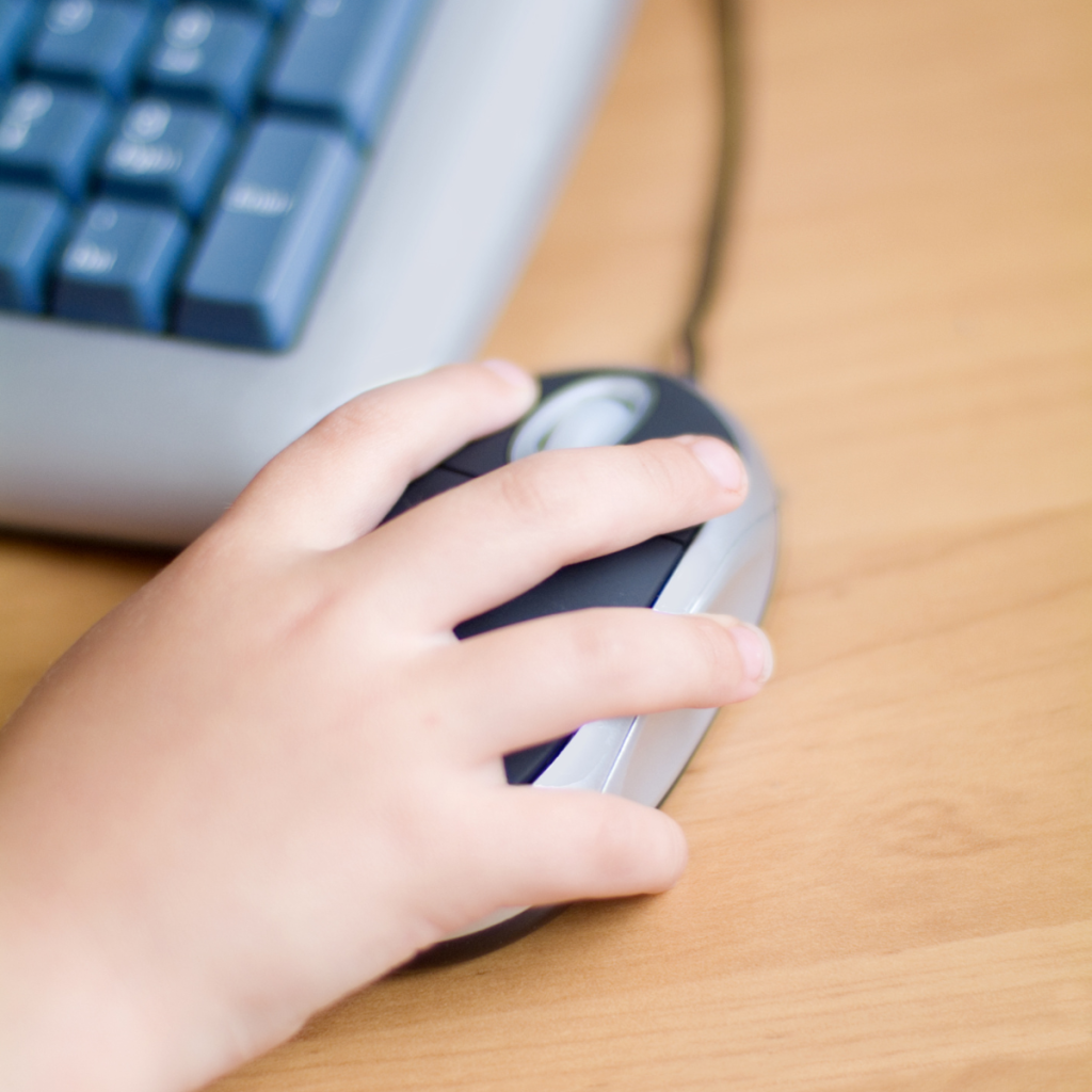Child’s hand on computer mouse.