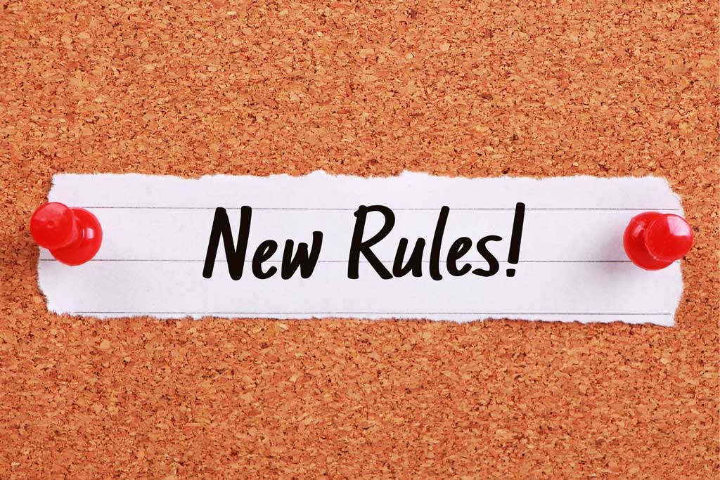 New Rules written on on a piece of paper tacked on a board.